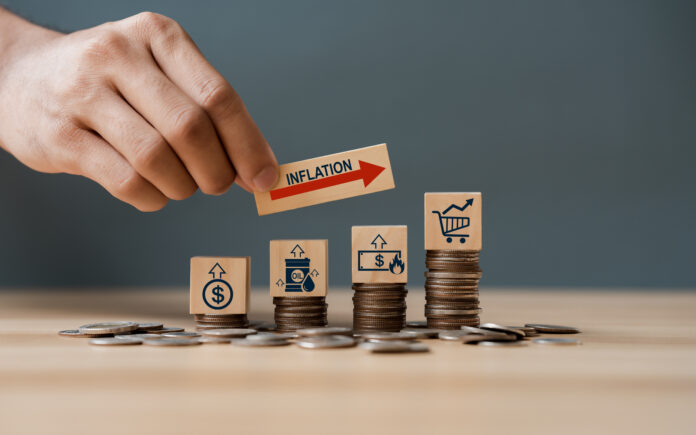 Hand putting wooden cube and inflation word a on coins in idea f Inflace
