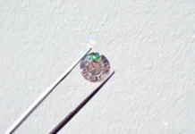 Diamantový trh niekoľko rokov stráca lesk. Najväčší hráč začal znižovať ceny Round-cut diamond held by tweezers against a light textured background, center-focused