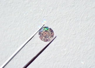 Diamantový trh niekoľko rokov stráca lesk. Najväčší hráč začal znižovať ceny Round-cut diamond held by tweezers against a light textured background, center-focused